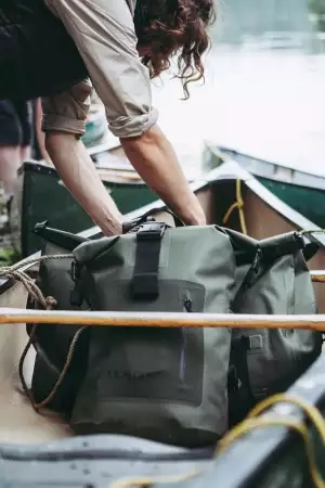 Loading Filson dry bags into a canoe