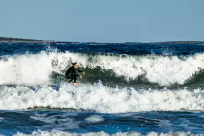 A surfer catches a clean break at Snowberry Beach in Scarborough, where Maine&rsquo;s southern coast offers some of the state&rsquo;s best waves