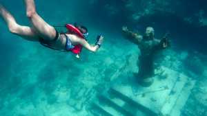 Woman taking picture of underwater statue