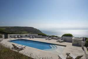 Azure blue sky reflected in the sea and swimming pool