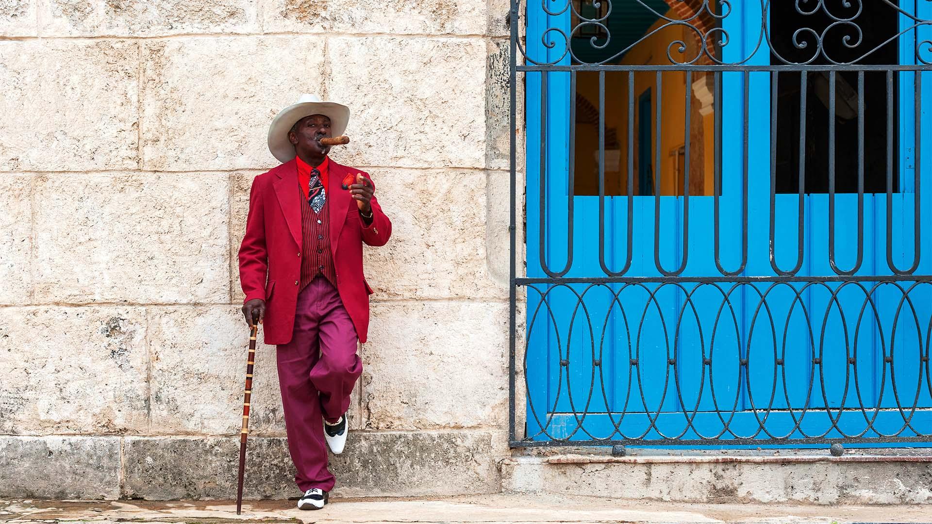 a man smoking a cigar on the street in Cuba a man smoking a cigar on the street in Cuba