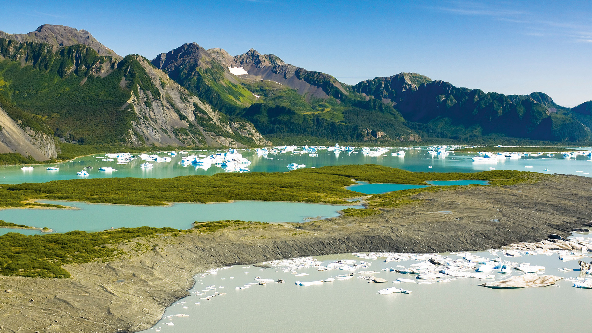 Female hiker overlooks Bear Glacier Lake in Kenai Fjords National Park, Kenai Peninsula, Southcentral Alaska Female hiker overlooks Bear Glacier Lake in Kenai Fjords National Park, Kenai Peninsula, Southcentral Alaska