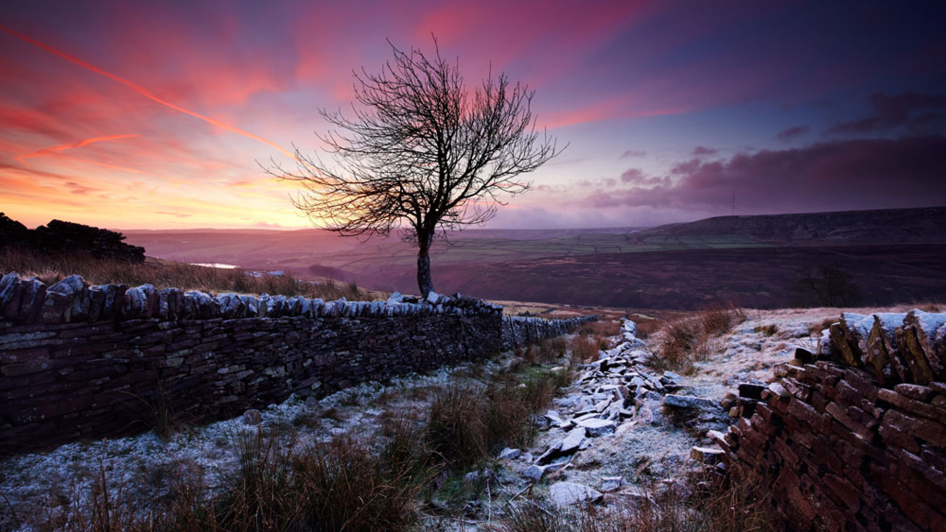 View of a snow-covered valley at sunset View of a snow-covered valley at sunset