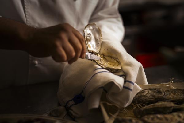 Chef Ettore Bocchia shucking an oyster