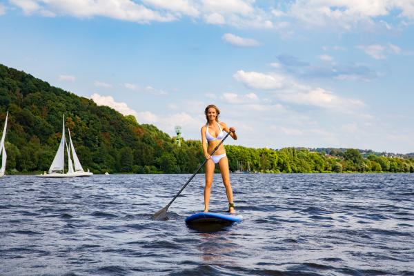 A woman paddleboards across Lake Baldeney