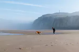 Richards and her dog Mimolette play together in front of Cap Blanc-Nez