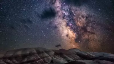 the glimmering stars of the Milky Way bathe the colourful layers of the Painted Hills of Oregon in a natural glow.