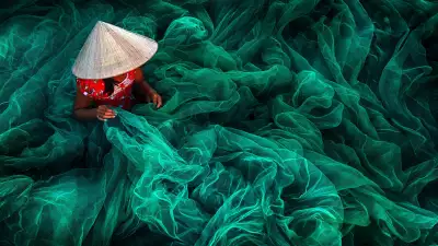 Vietnamese woman weaving a handmade fishing net