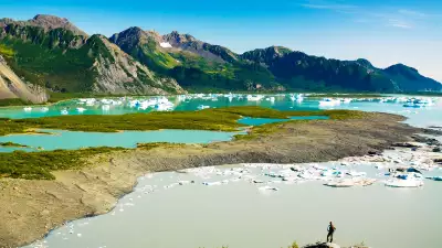 Female hiker overlooks Bear Glacier Lake in Kenai Fjords National Park, Kenai Peninsula, Southcentral Alaska, Summer