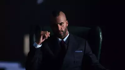 Ricky Whittle, star of American Gods poses in a suit and macintosh