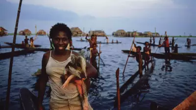 A woman by a lake at the mouth of the Sepik river