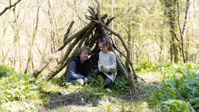 A family playing in the woods at The Mole Resort