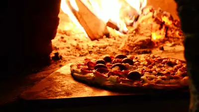 A pizza smouldering in a wood-fired oven
