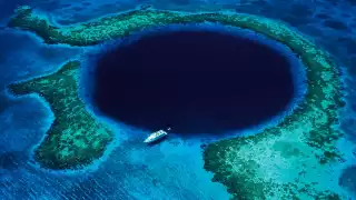 A boat passing over the Great Blue Hole of Belize