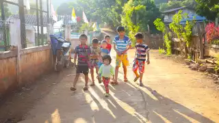 A group of children walking down a track in Thailand