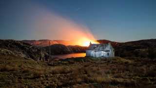 Fire behind a dilapidated croft on Harris