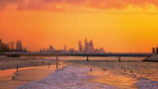 Dubai beach at sunset with skyline in background