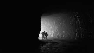 Cyclists coming into a tunnel in black and white in France