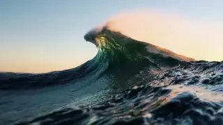 Light glowing through the top of an incoming wave