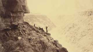 Two men stand next to the Grand Canyon near the Colorado River
