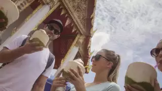 Travellers drinking coconut water in Thailand