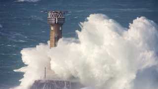 Waves breaking on Longships watch in Sennen Cove, Cornwall
