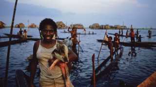 A woman by a lake at the mouth of the Sepik river