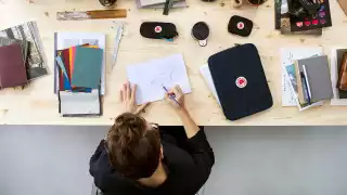 A designer working at a desk with the Fjallraven Kanken Essentials kit