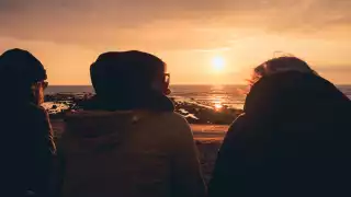 Friends on the beach at sunset in Cornwall