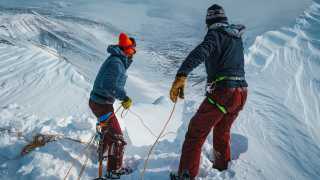 Belaying down into a couloir on a splitboarding expedition in The Kebnekaise, Sweden