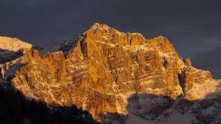 Enrosadira (alpenglow) on the mountain face in The Dolomites
