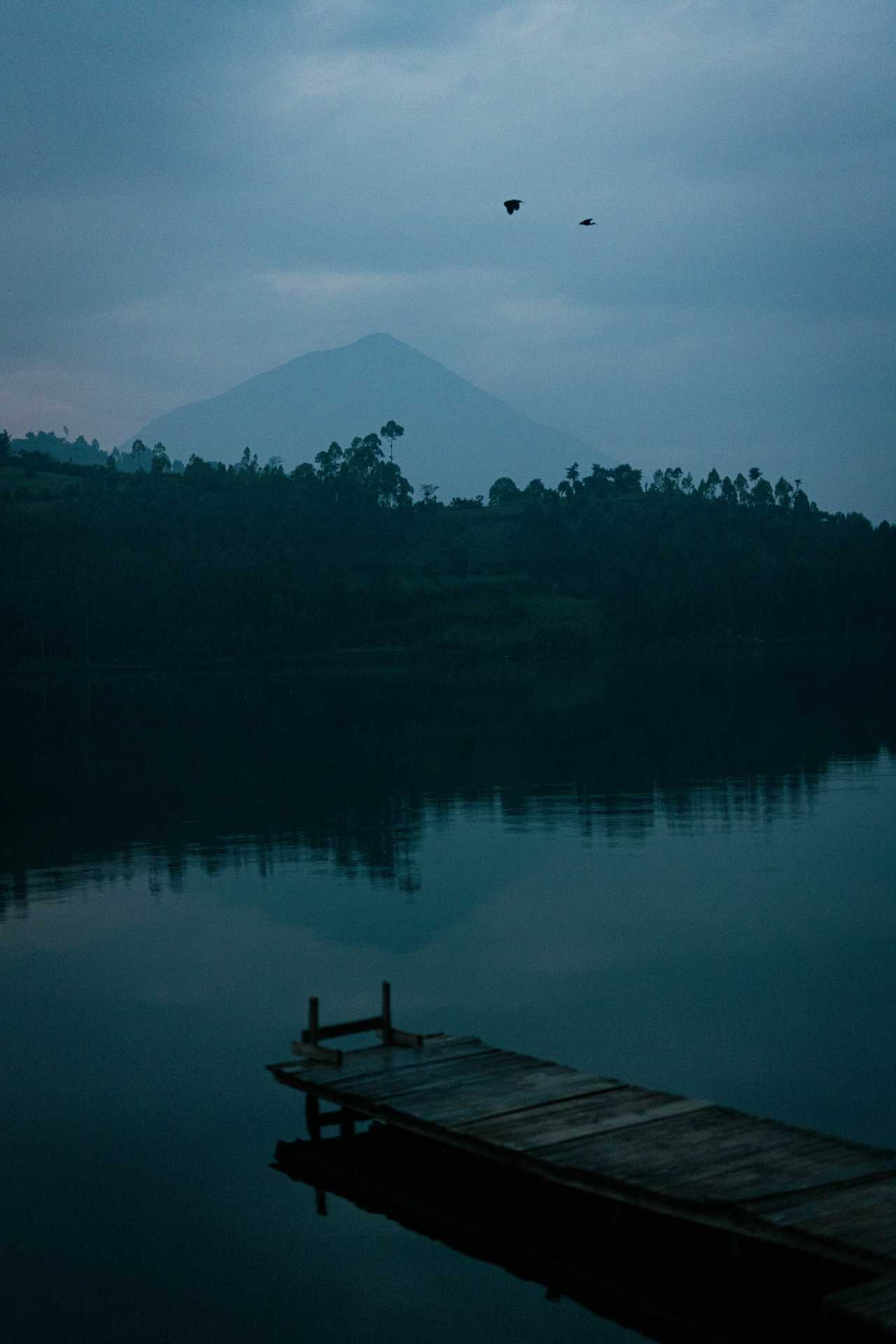 Under the towering slopes of Mount Muhavura lies the serene Lake Kayumba, an oasis of calm tucked away among the hills