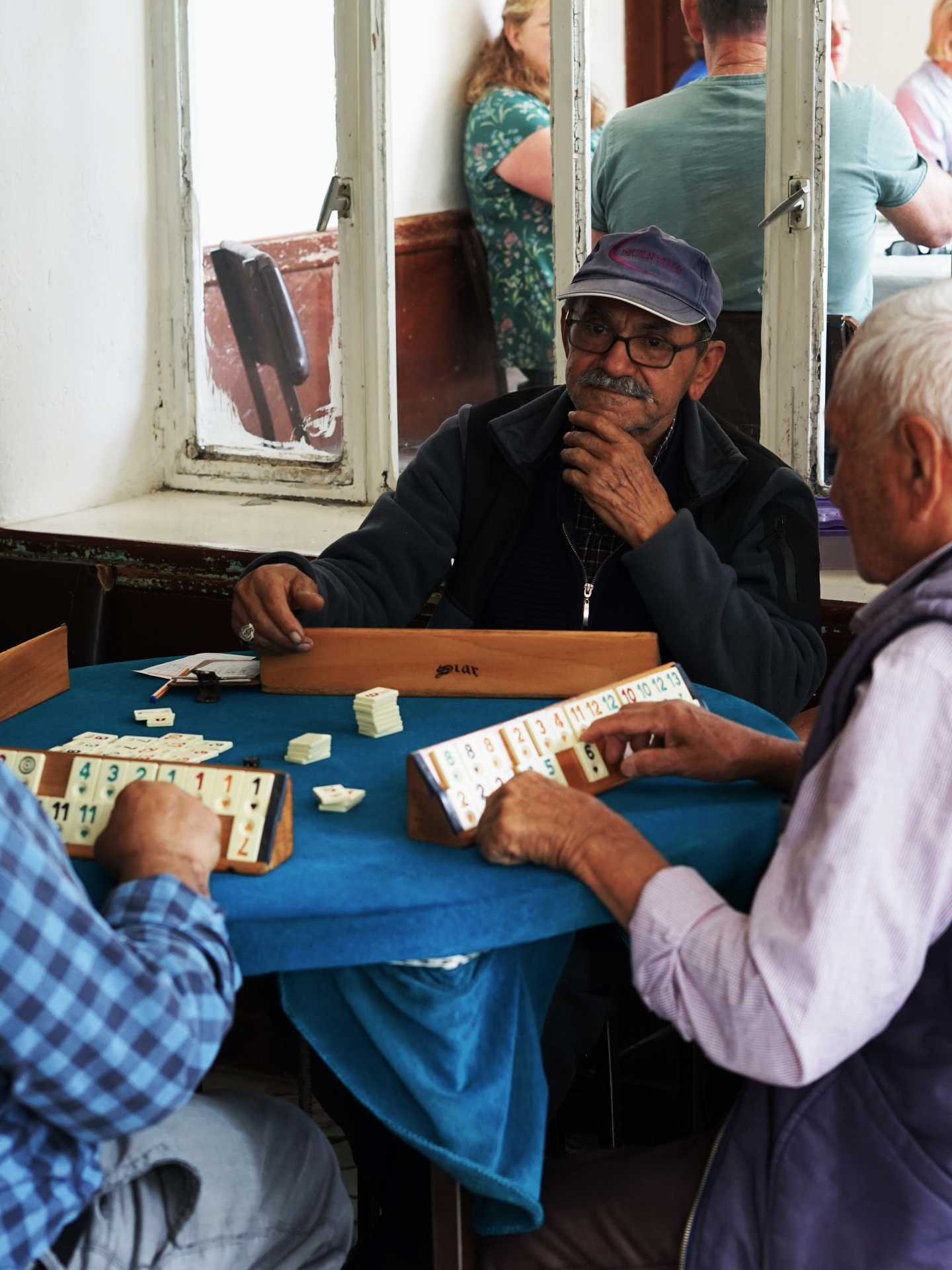 A man concentrates playing a game of okey in a village in Kasımlar A man concentrates playing a game of okey in a village in Kasımlar