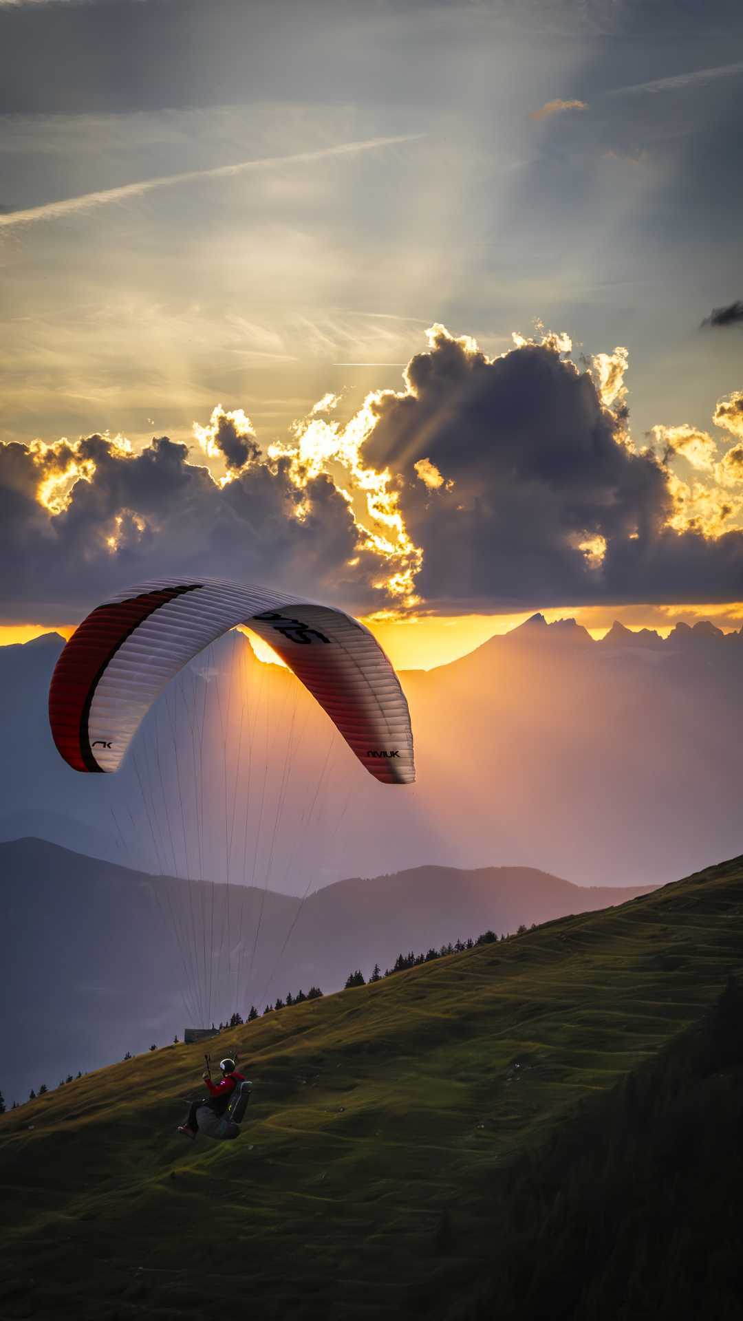 A paraglider swoops past a hill in Verbier