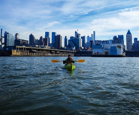 Hannah Summers kayaks with the New York skyline in the background
