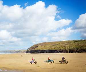 Family cycle on the beach holiday Cornwall