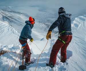 Belaying down into a couloir on a splitboarding expedition in The Kebnekaise, Sweden