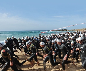 Swimmers enter the water in the first leg of the Chia Laguna Triathlon
