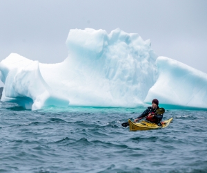 Kayaking past icebergs in Newfoundland, Canada. Photograph by Destination St. John's