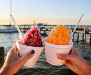 People holding up shave ice on a dock in Florida