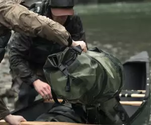 Loading a Filson dry duffel bag into a canoe