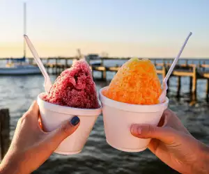 People holding up shave ice on a dock in Florida